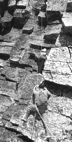 Deux alpinistes sur une paroi rocheuse escarpée.